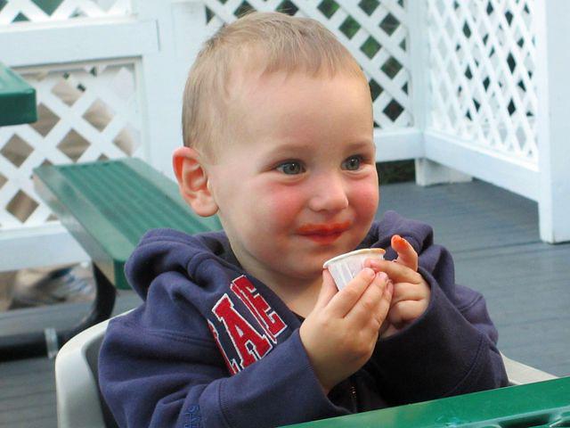 So hungry, he is eating catsup