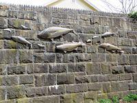 "Native Fish" mounted on stone wall along the trail